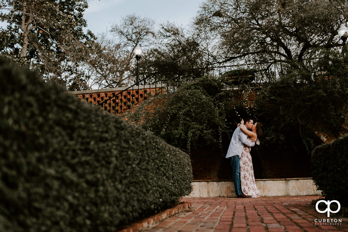 Man dancing with his fiancee in the rose garden at Furman during their engagement session.