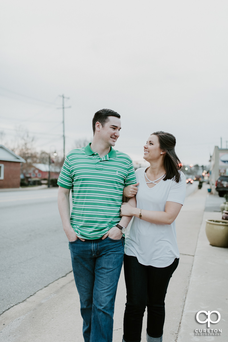 Engaged couple walking the streets of downtown Travelers Rest, SC.