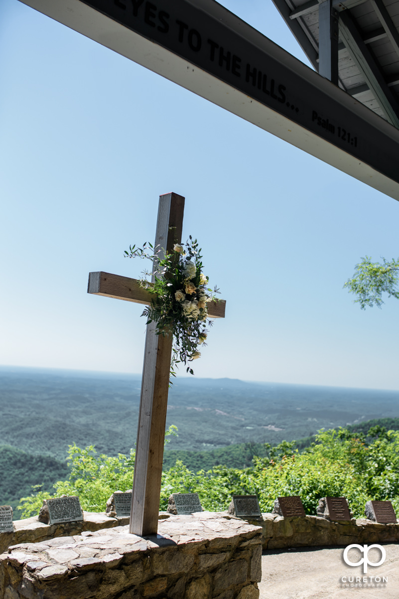 Cross at Pretty Place with flowers placed on it.