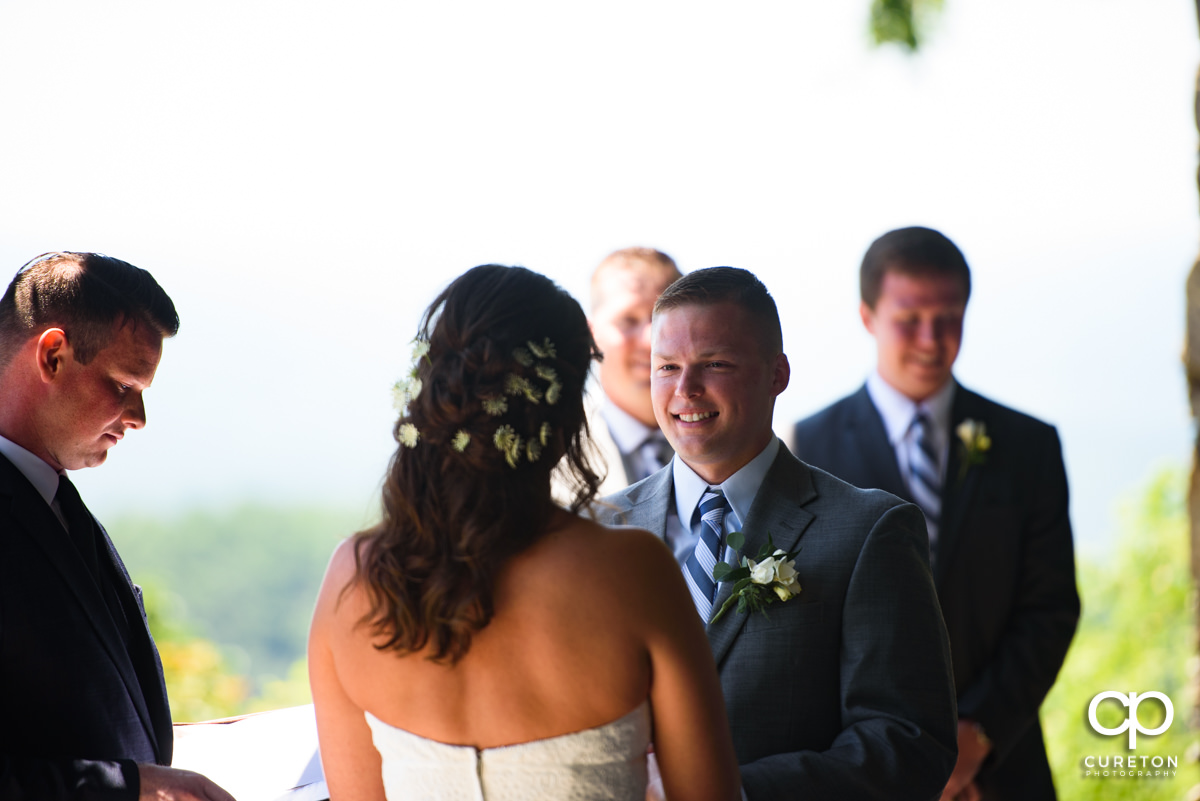 Groom smiling at his bride during the Symmes Chapel wedding ceremony.