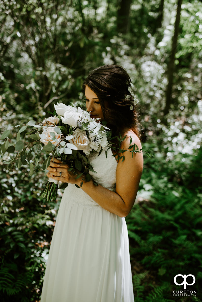 Bride smelling her bouquet of flowers after her wedding.