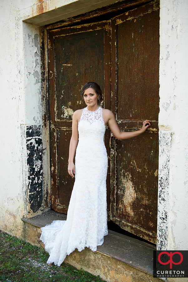 Bride standing in a disheveled doorway at the Taylors Mill. 