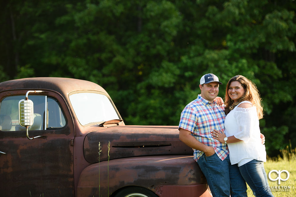 Future married couple leaning on a vintage truck during a Travelers Rest engagement session.