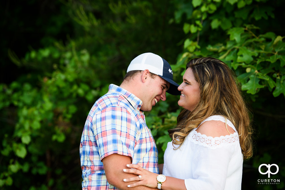 Future bride and groom laughing.