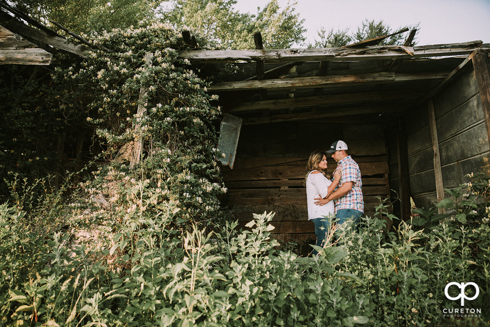 Engaged couple in an overgrown shed during a Travelers Rest engagement session.