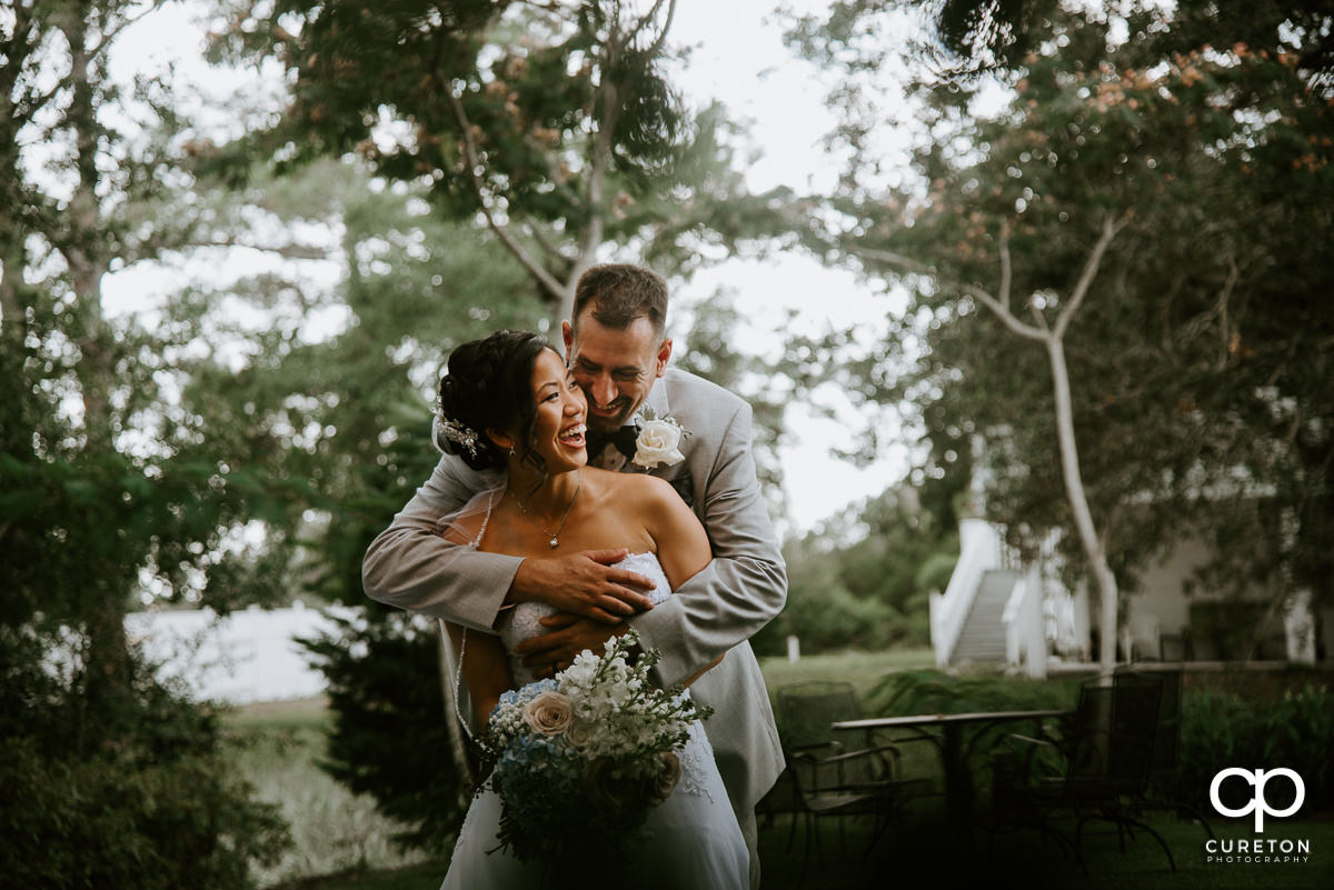 Groom hugging his bride outside the Tybee Island Wedding Chapel after their wedding.