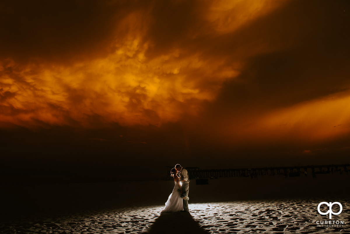 Bride and groom on the beach at sunset after their wedding at the Tybee Island Wedding Chapel.
