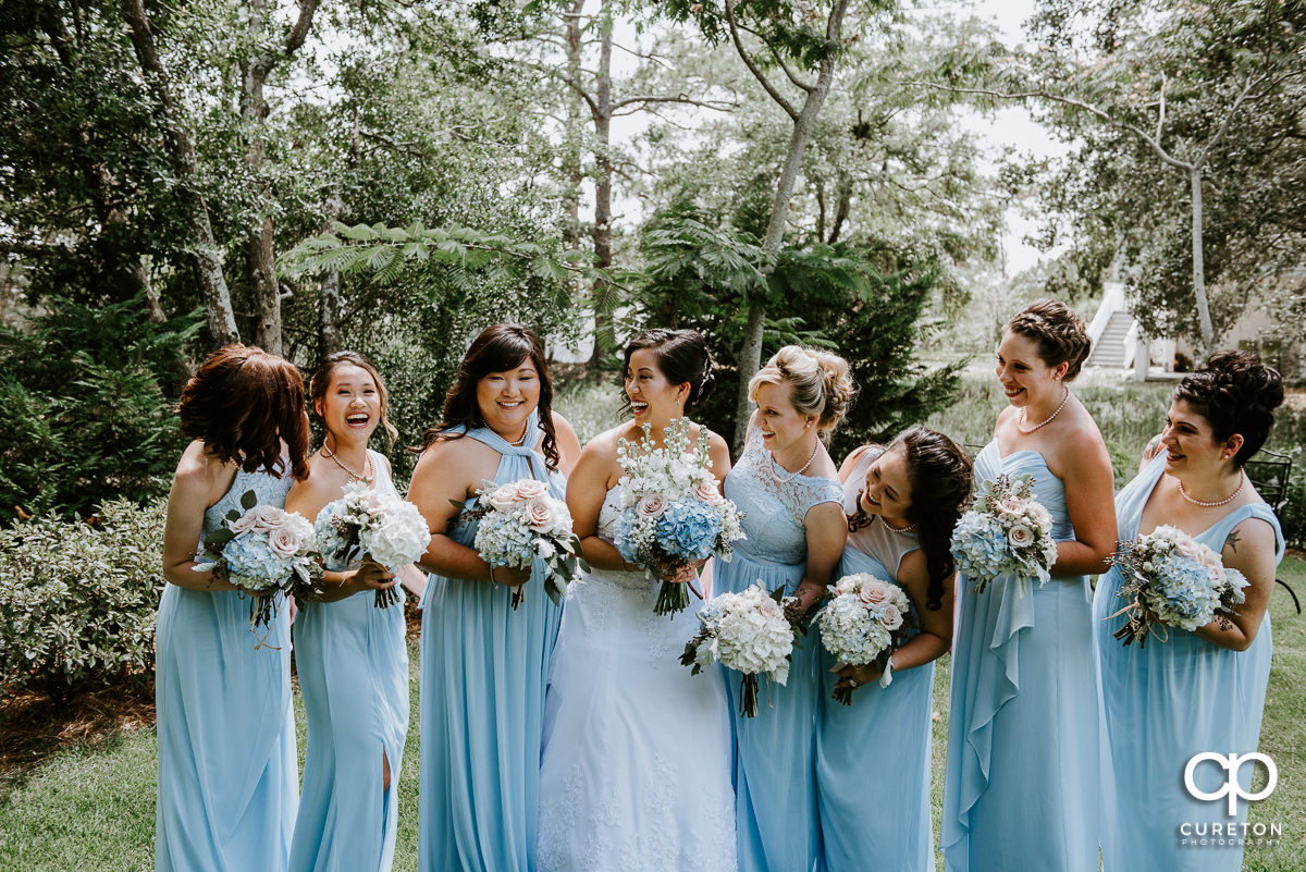 Bride and bridesmaids laughing with each other.