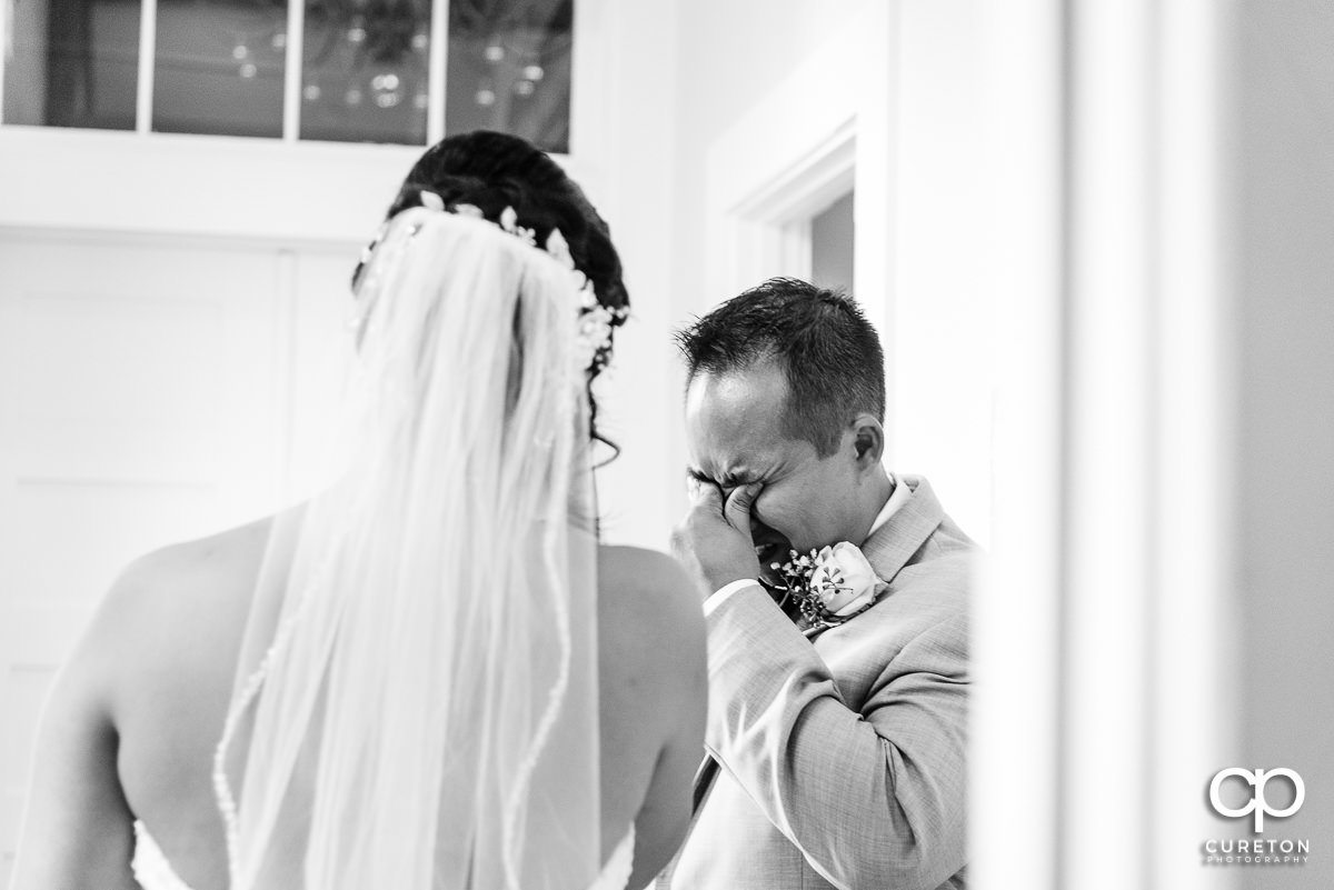 Bride's brother crying when he sees his sister in her dress for the first time before the ceremony.