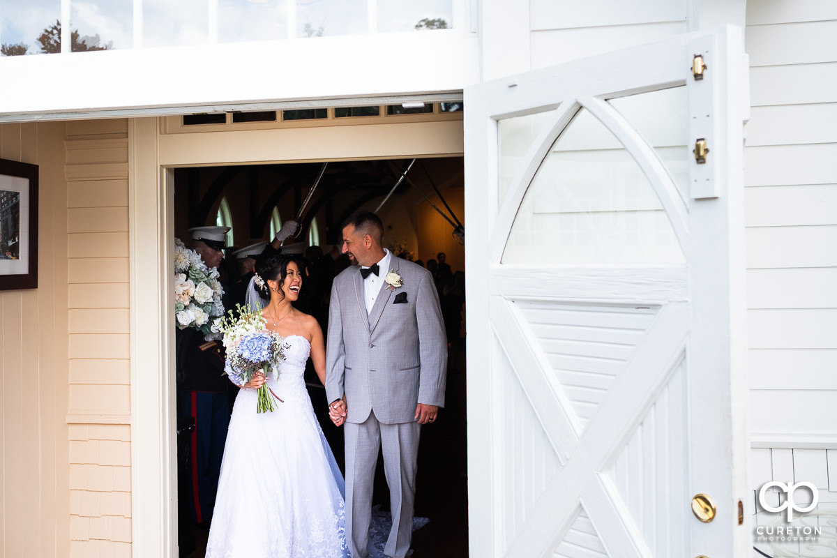 Bride and groom smiling and laughing leaving their Tybee Island wedding ceremony.