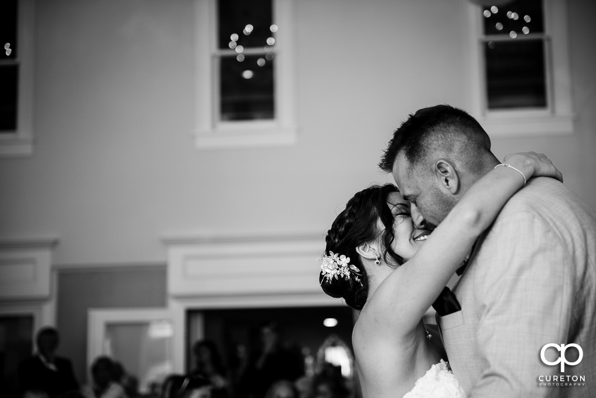 Bride kissing her groom during their first dance.