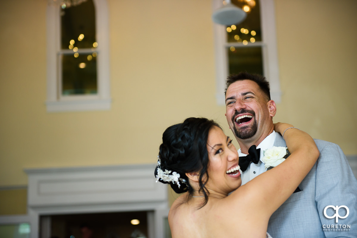 Bride and groom laughing during their first dance at the wedding reception in Tybee Island.