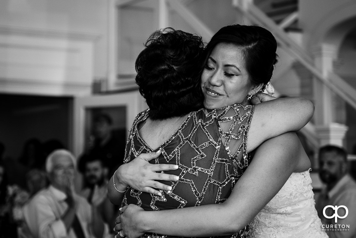 Bride hugging her mom.