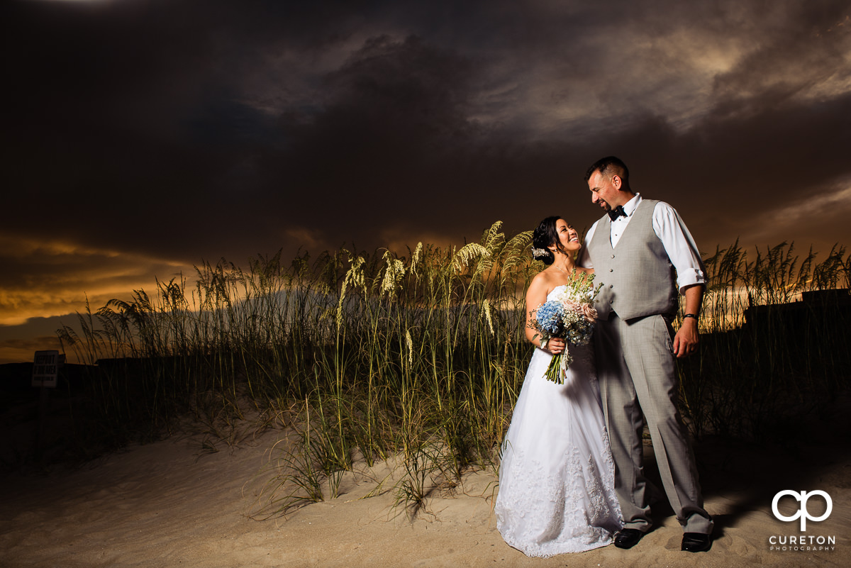Bride and groom on Tybee Island beach at sunset after their wedding.