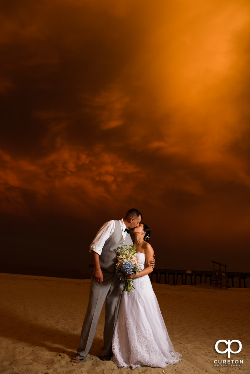 Bride and groom walking on the beach at sunset after their Tybee Island wedding.