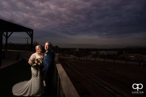 Bride and groom on a rooftop under a purple sky in Greenville.
