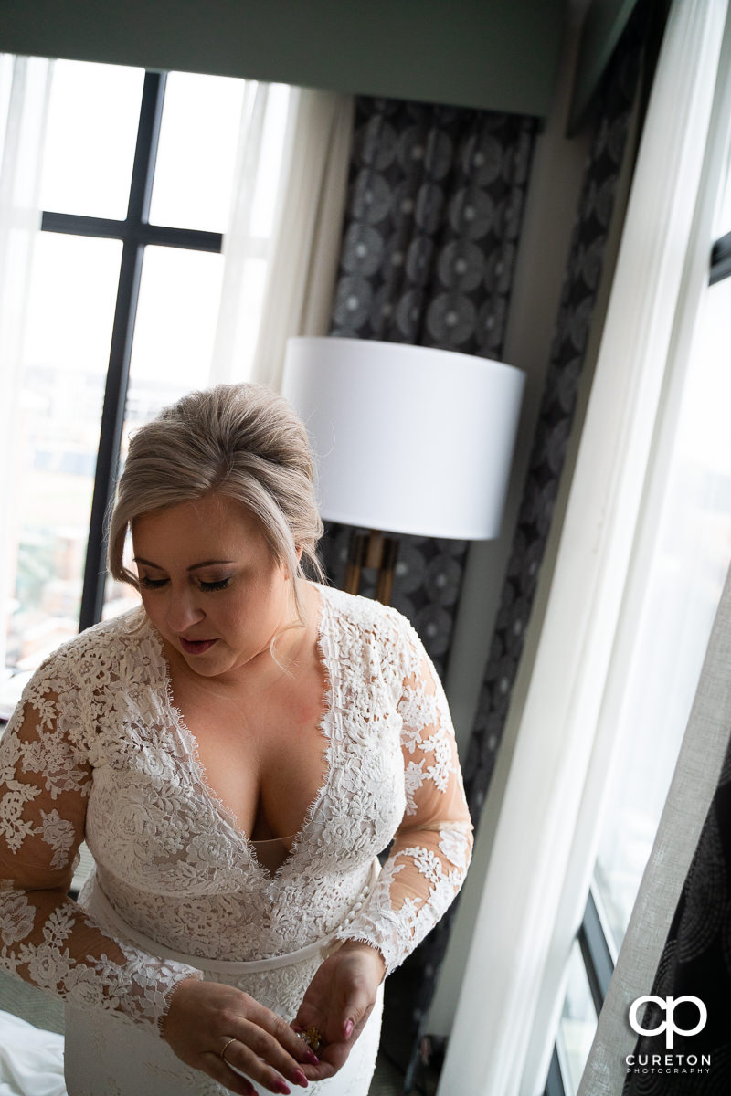 Bride standing in window light.