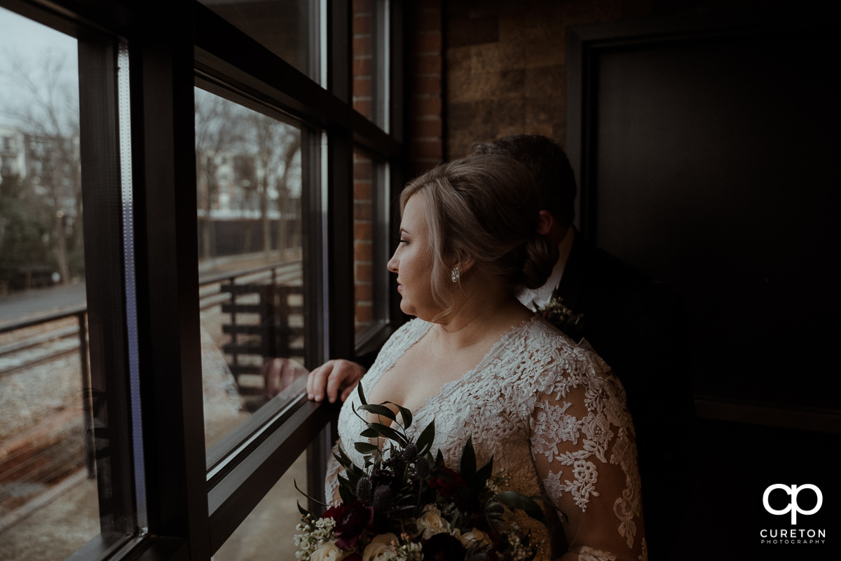 Bride looking out of the winery window.