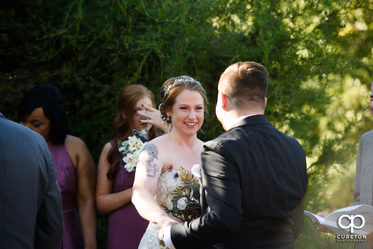 Bride smiling at her groom during the ceremony.