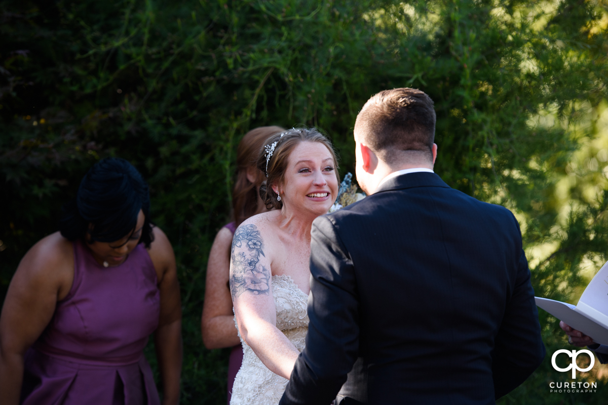 Bride smiling at the groom at the wedding ceremony at the Viewpoint at Buckhorn Creek.