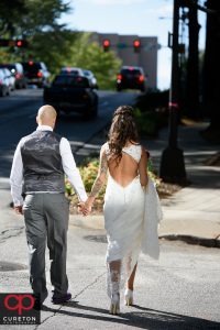 Bride and groom walking down the street downtown.