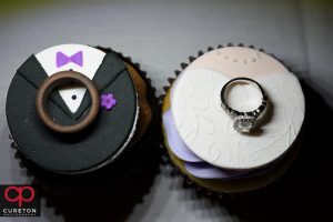 Wedding rings on top of cupcakes.