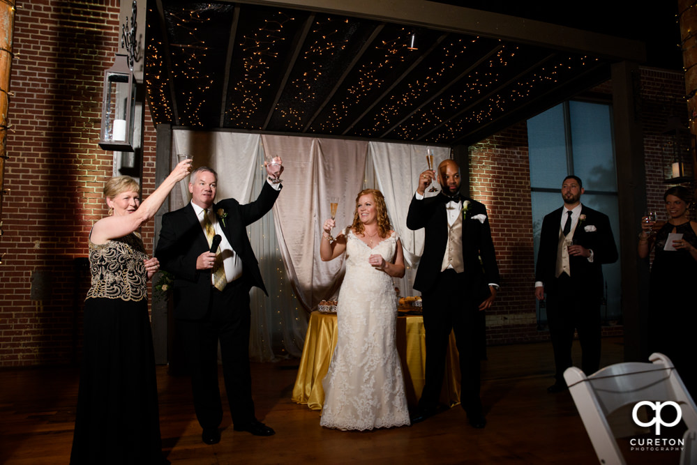 The wedding party gives a toast to the bride and groom.