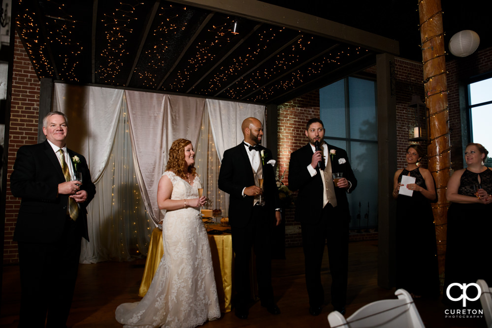 The wedding party gives a toast to the bride and groom.