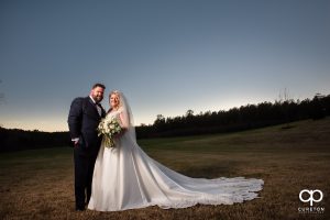 Bride and groom in a pasture.