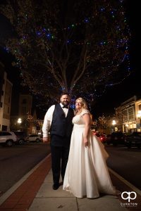 Bride and groom under Christmas lights in downtown Anderson,SC.