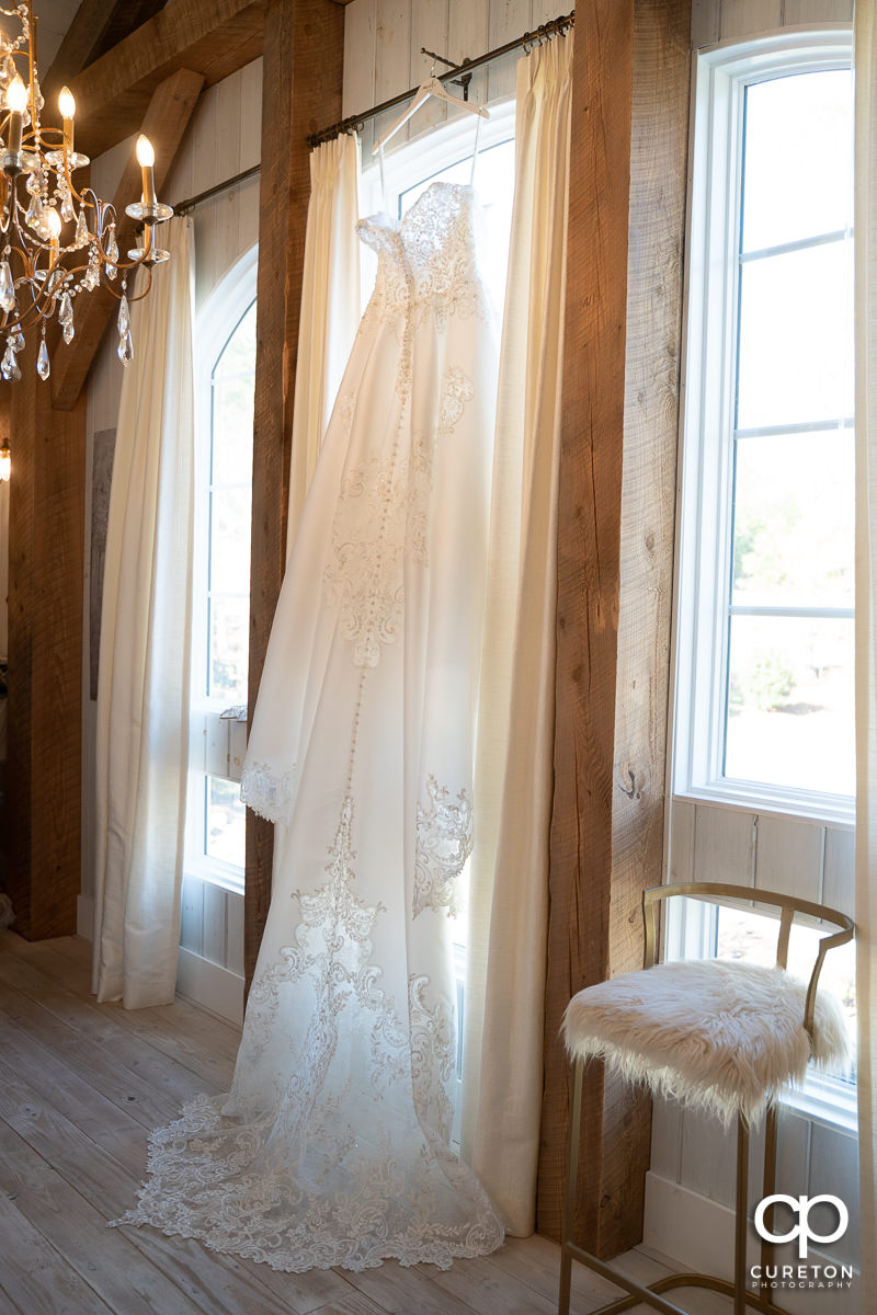 Bridal dress hanging in a window.