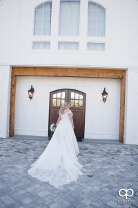 Bride walking into a white barn.