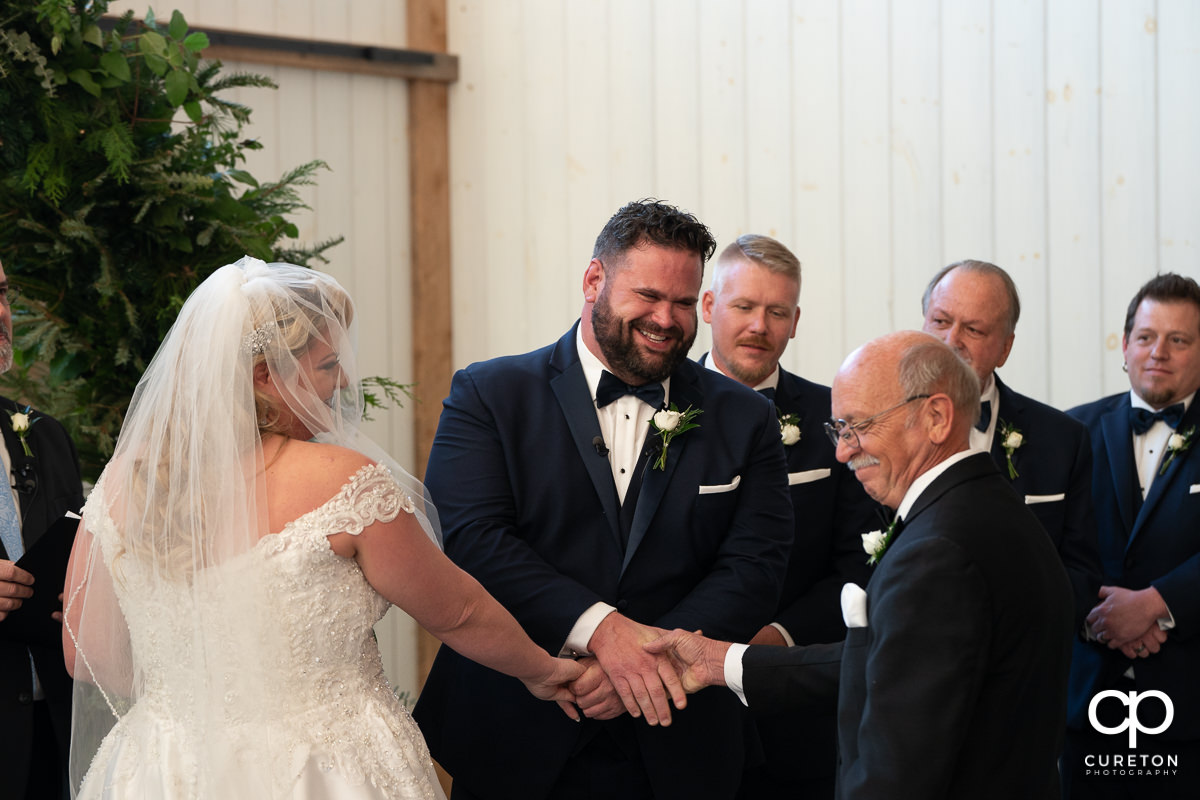 Groom shaking his bride's dad's hand.