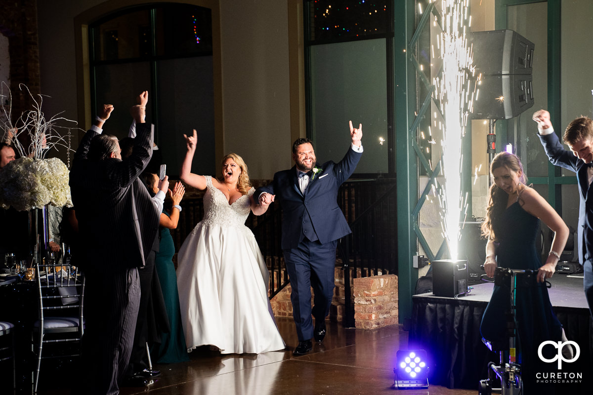 Bride and groom making an entrance into the wedding reception with spark fountains at Bleckley Station in Anderson,SC.