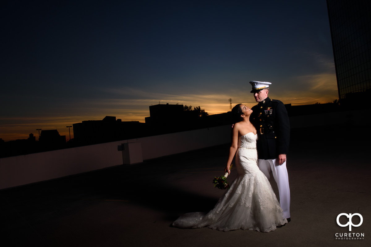 Bride and Groom on a rooftop in downtown Greenville at sunset after their wedding.