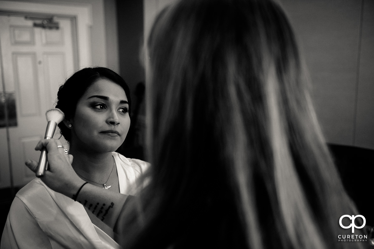Bride getting makeup applied before the ceremony.