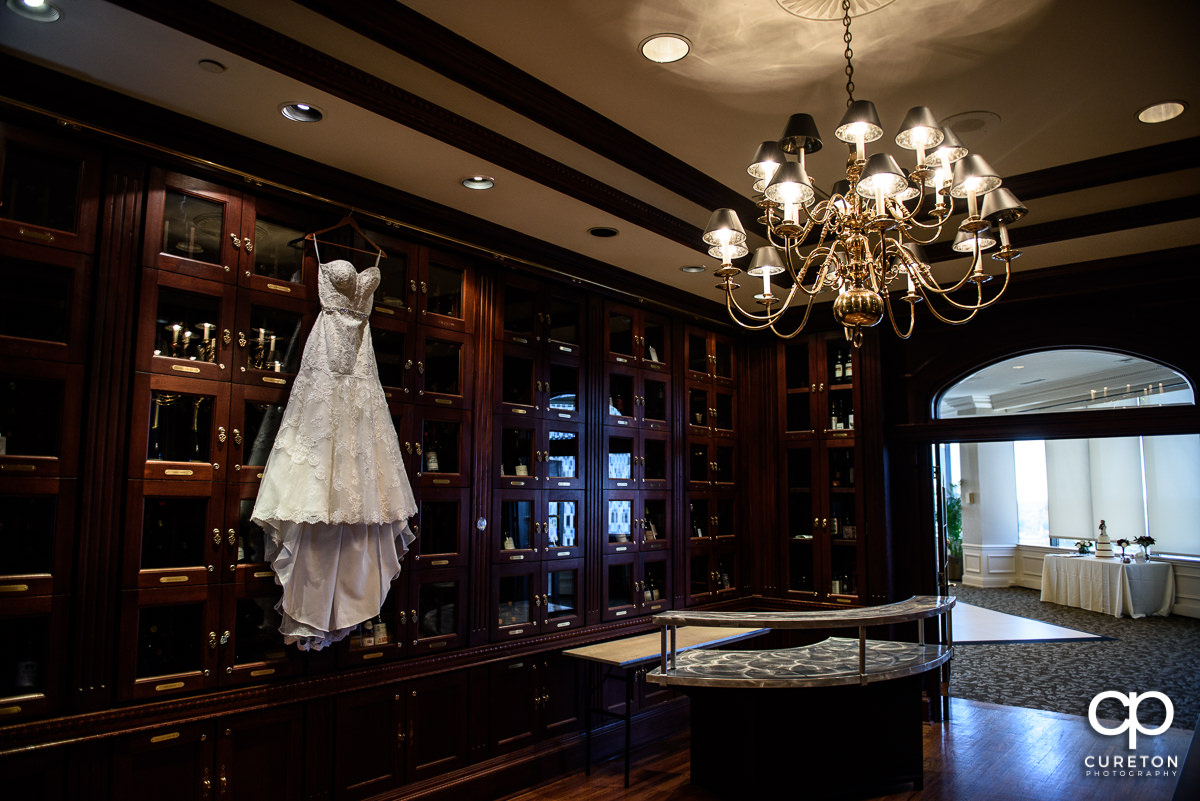 Bride's dress hanging in the wine room at The Commerce Club before the wedding.