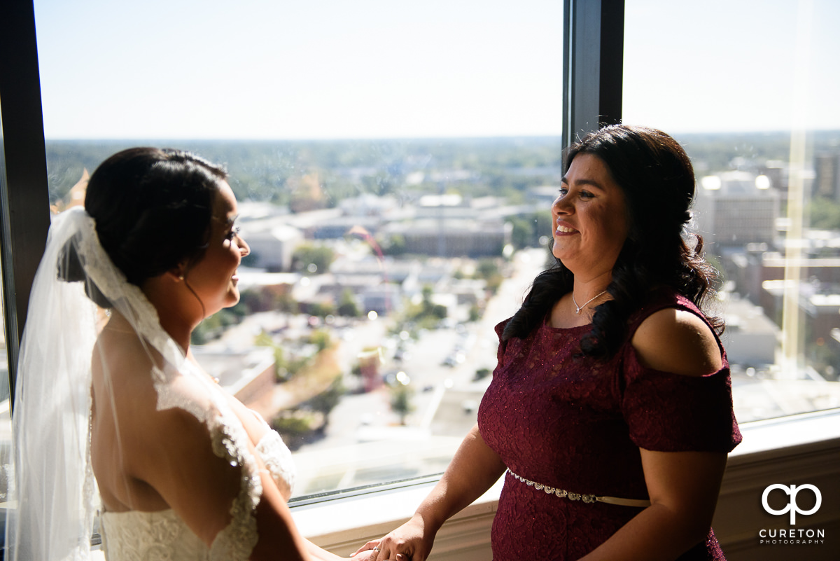 Bride and her mother sharing a moment in the window before the wedding.