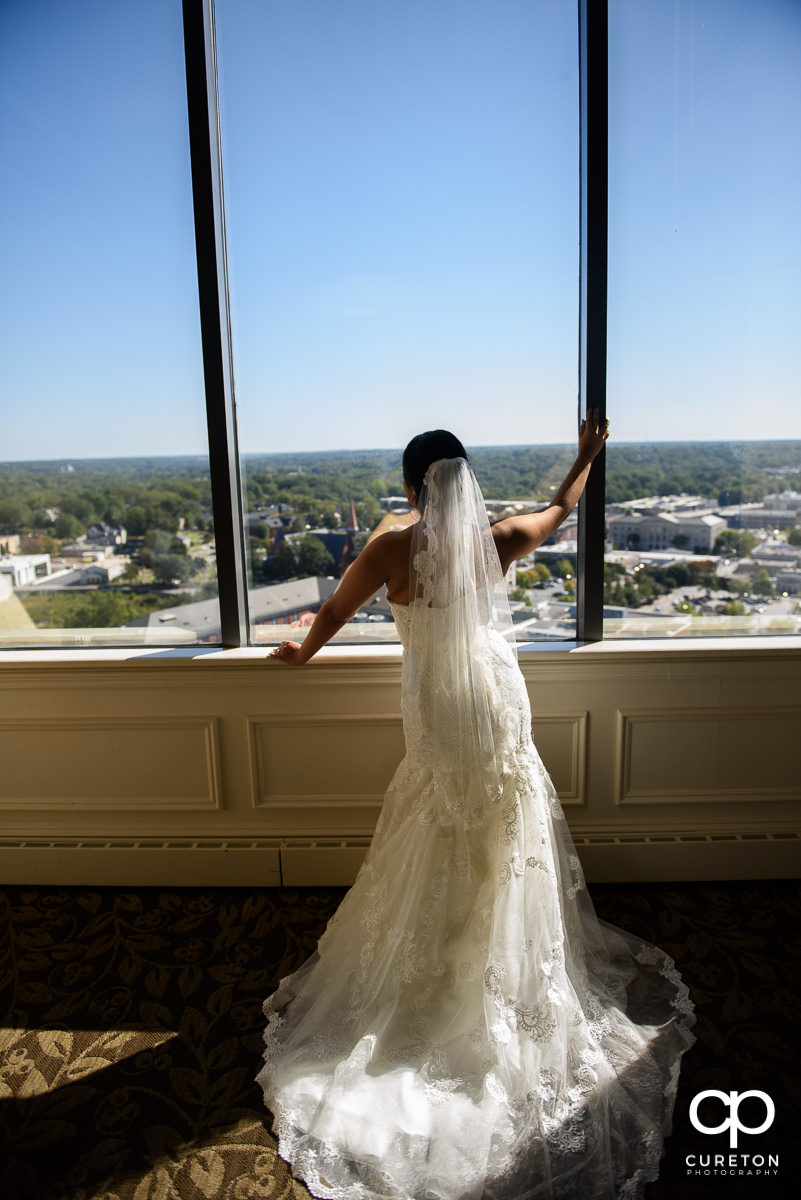 Bride standing in the window at The Commerce Club before the ceremony.