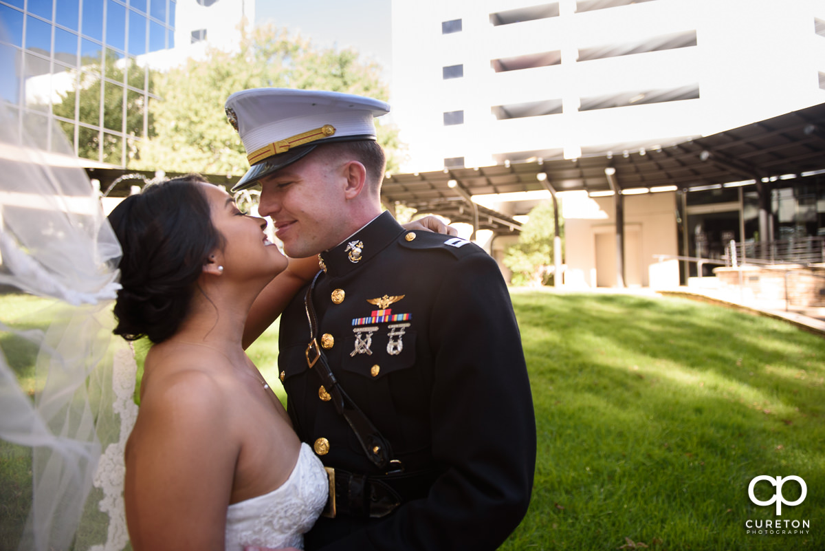 Bride and groom kissing with the veil blowing in the wind.