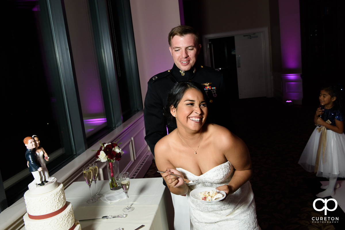 Bride laughing at the cake cutting.