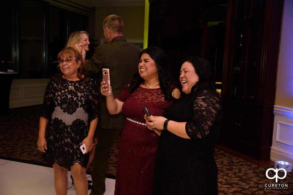 Wedding guests recording dancing on their cell phones.