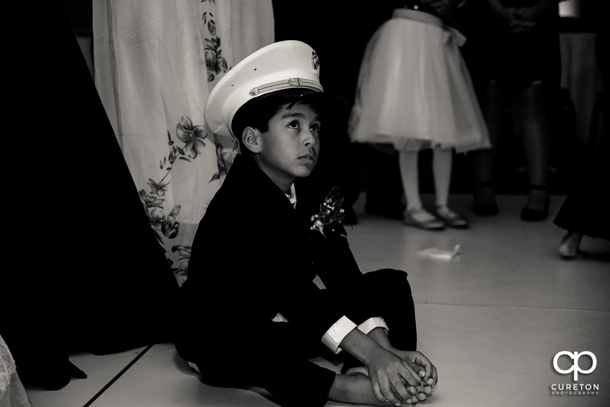 Ring bearer wearing the grooms military dress hat.