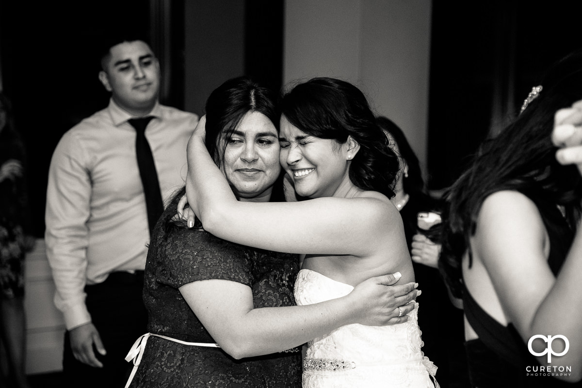 Bride getting emotional with her mother at the wedding reception.