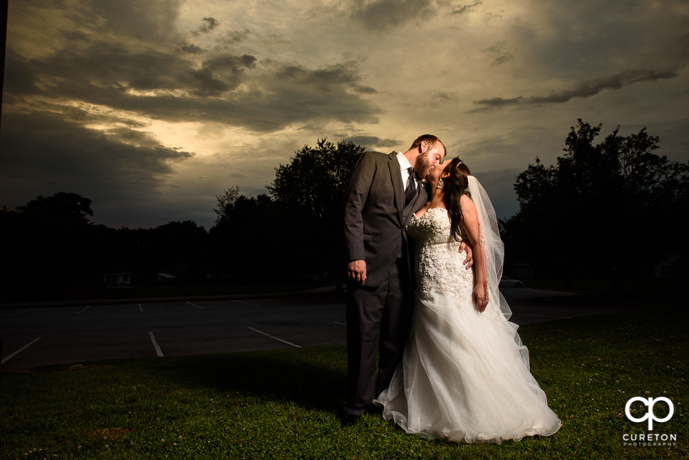 Bride and Groom kissing at sunset after their wedding at The Loom a venue in Simpsonville, SC.