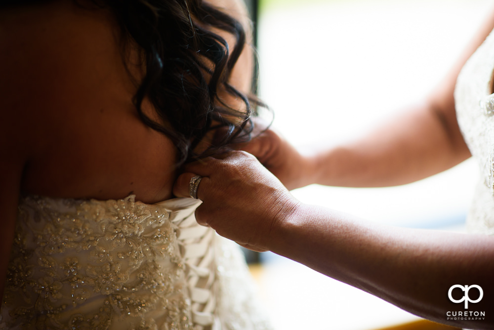 Bride getting her dress buttoned.