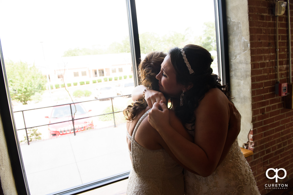 Bride hugging her mom before the wedding.