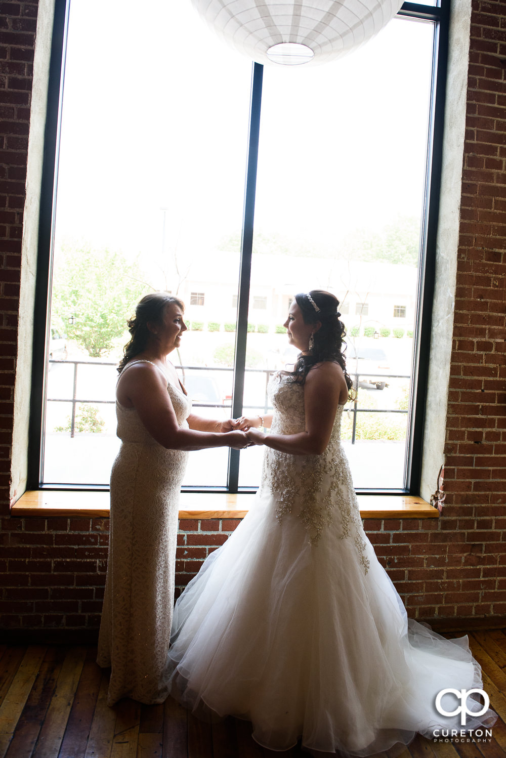 Bride and her mom in perfect window light at the Loom in Simpsonville before the wedding.