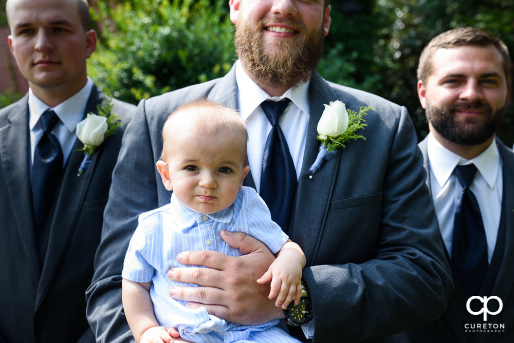 Groom holding his infant son.
