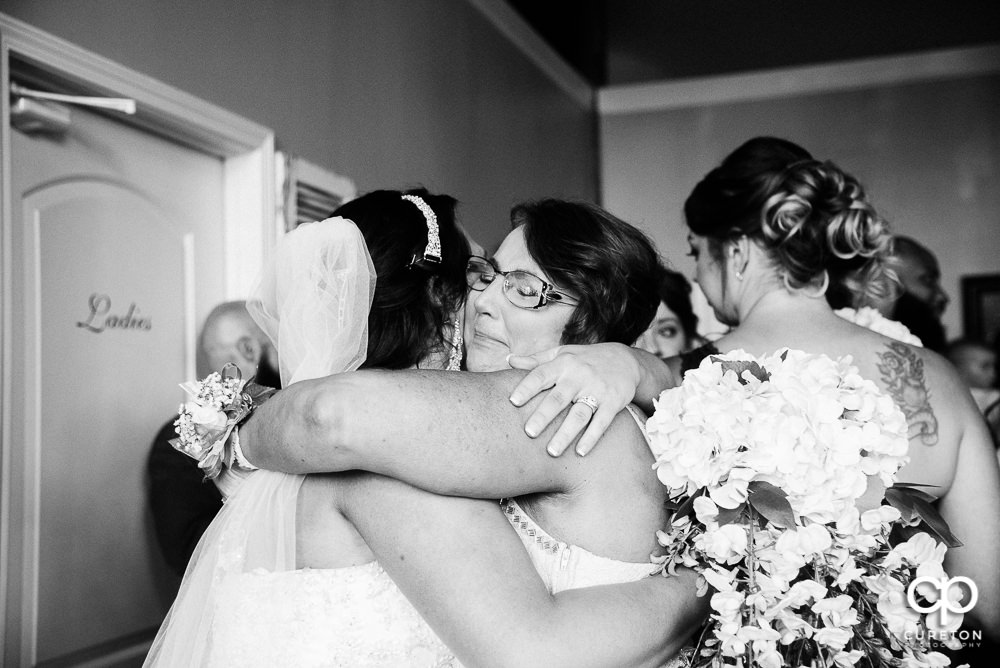 Bride and her mom hugging after the wedding.